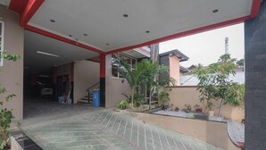 A covered outdoor area with a tiled floor, a staircase, and potted plants. - RedDoorz near E Walk Mall Balikpapan (Balikpapan)