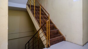 A staircase with wooden steps and metal railings. - RedDoorz @ Pengayoman Panakkukang 2 (Makassar)
