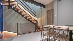 Een modern interieur met een trap, eettafel en stoelen.