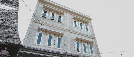 Un edificio de varios pisos con techo plano y balcón.
