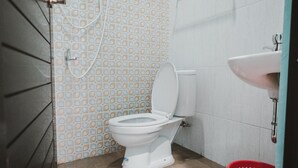 A bathroom with a toilet, a shower, and a sink. - RedDoorz near RSUD Koja (Jakarta)