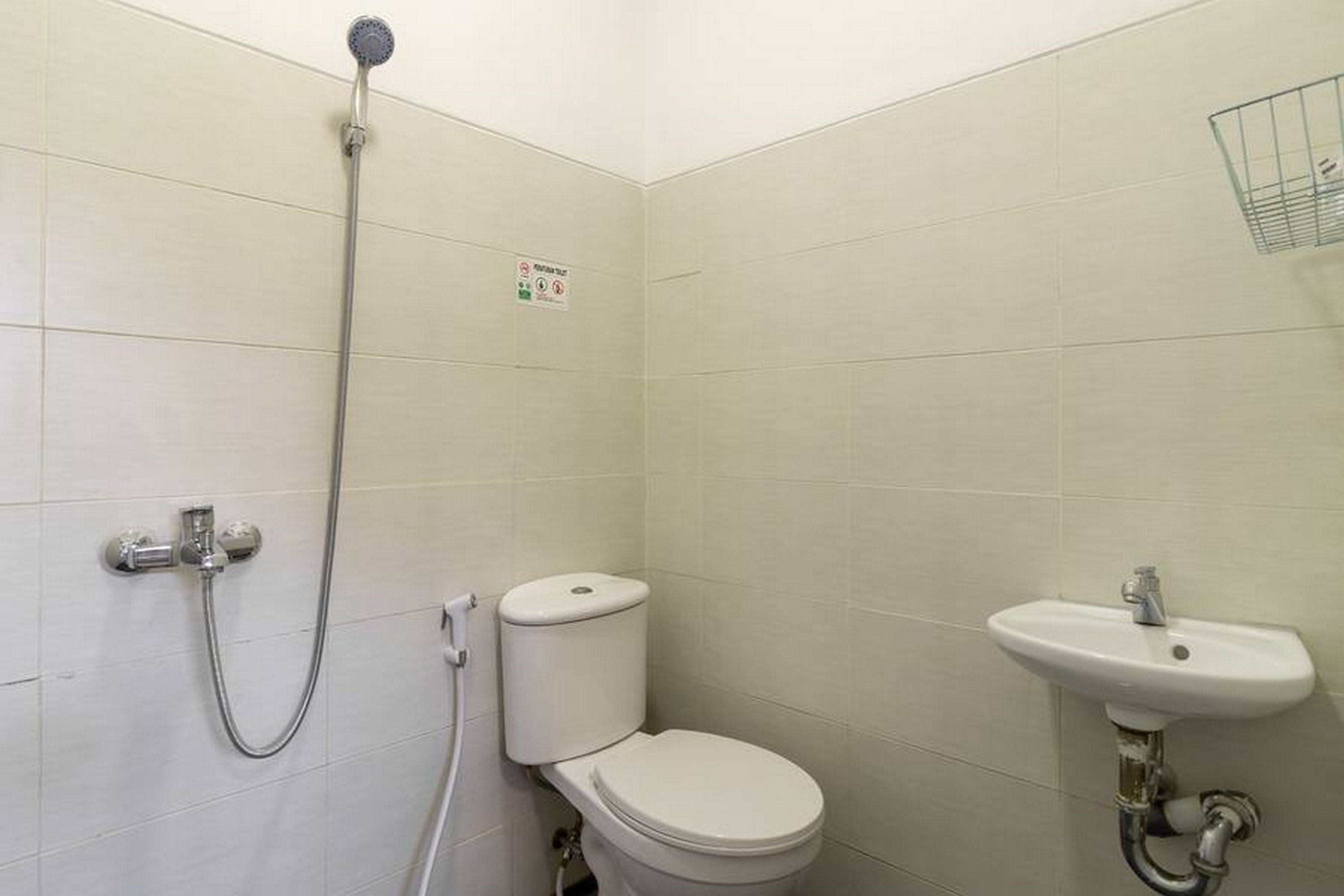 A small, clean bathroom with a toilet, a sink, and a shower.