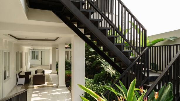 A modern interior with a staircase, a reception area, and a view of the outdoors. - RedDoorz Plus near Exit Toll Puncak 2 (Ciawi)