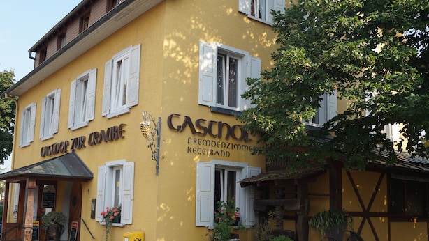 Un edificio giallo con la scritta "CASCHOL" e "CASCHOL CREMBOEZIMMER KECELBATT".