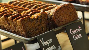 Una exhibición de productos horneados con etiquetas que indican que son veganos, hechos con pan, chocolate y nueces.
