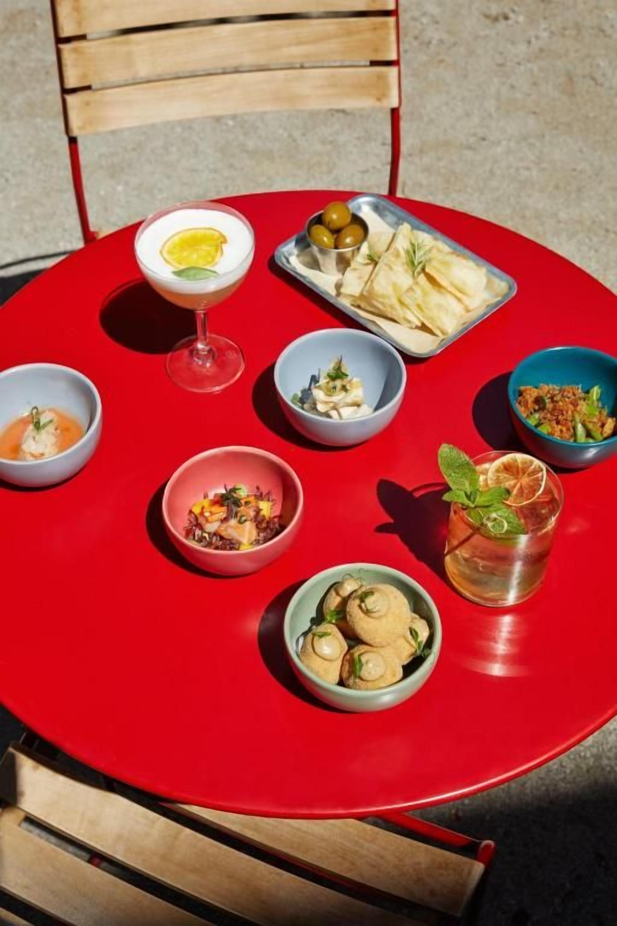A red table with various dishes and a drink, suggesting a dining setting.