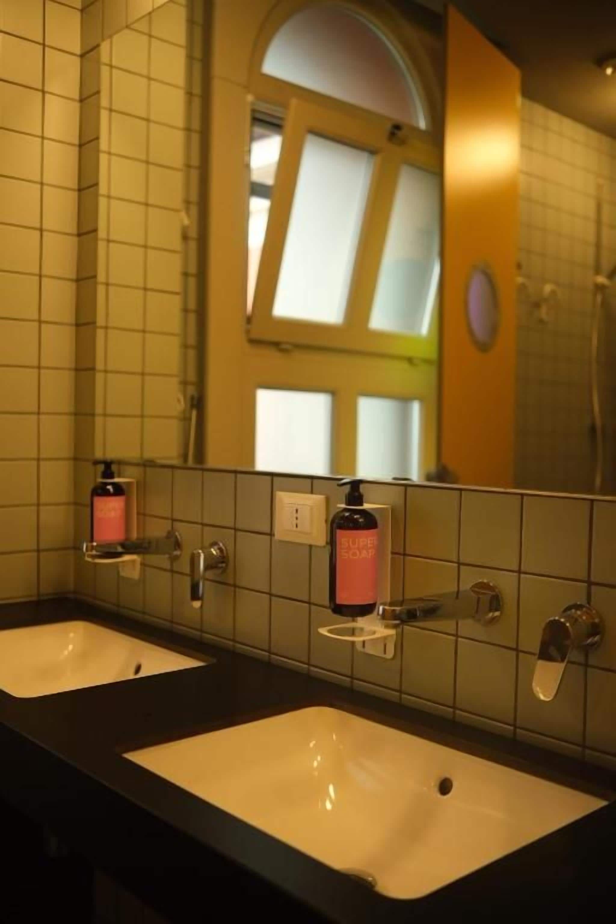 A bathroom with two sinks, a mirror, and a window.