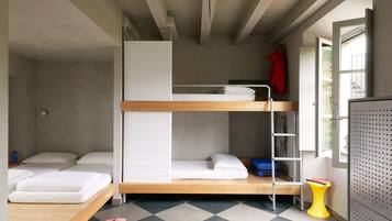 Habitación compacta con literas, un escritorio pequeño y una ventana con vistas.