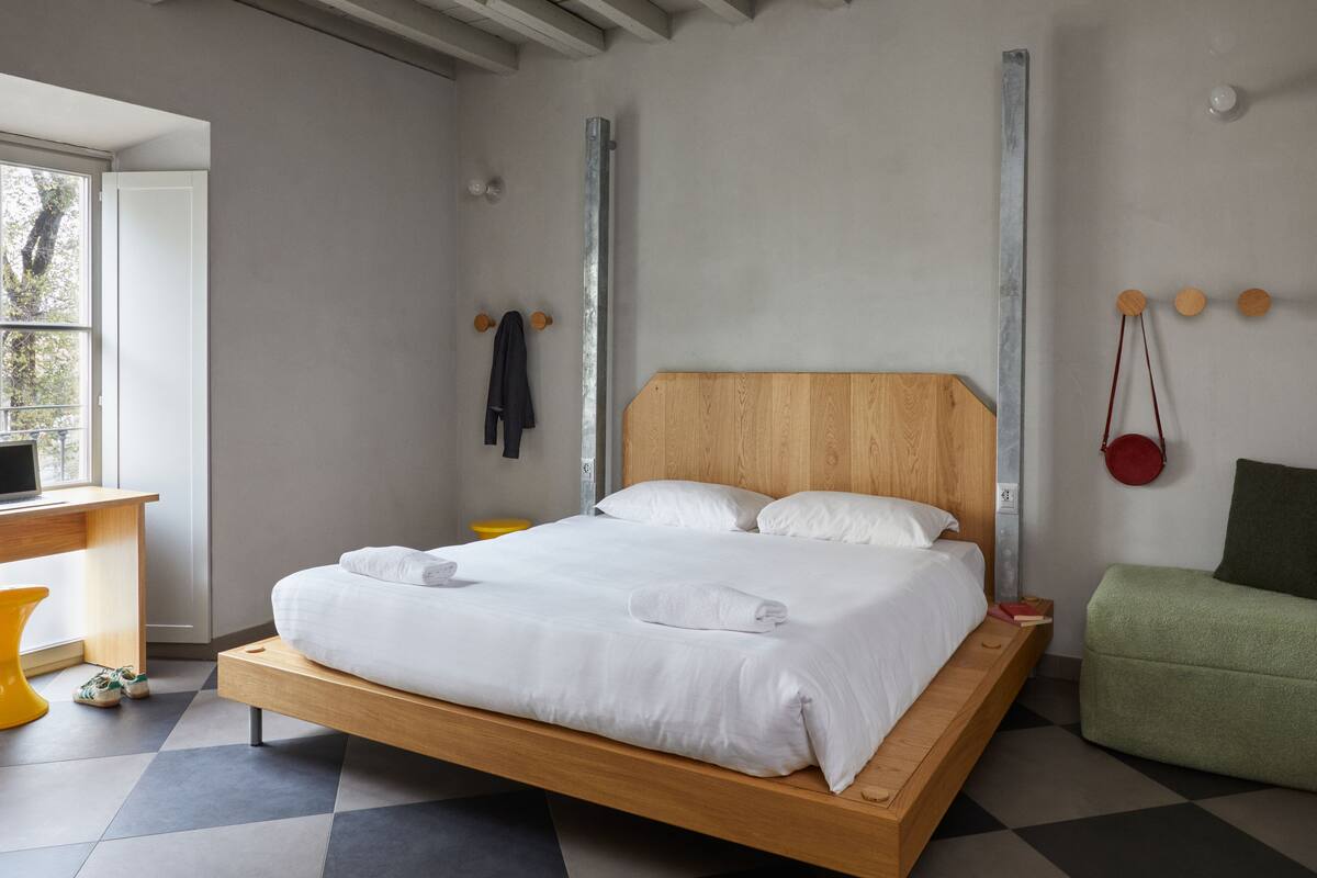 Un dormitorio moderno con una cama de madera, un escritorio y una silla.