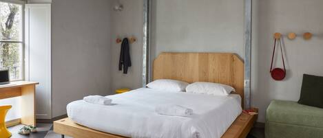 A modern bedroom with a wooden bed, a desk, and a chair.