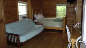 A cabin with two wooden beds, a wooden table, and a window. - Acadia Explorer Cabin Rentals Cabin 1  (Southwest Harbor)