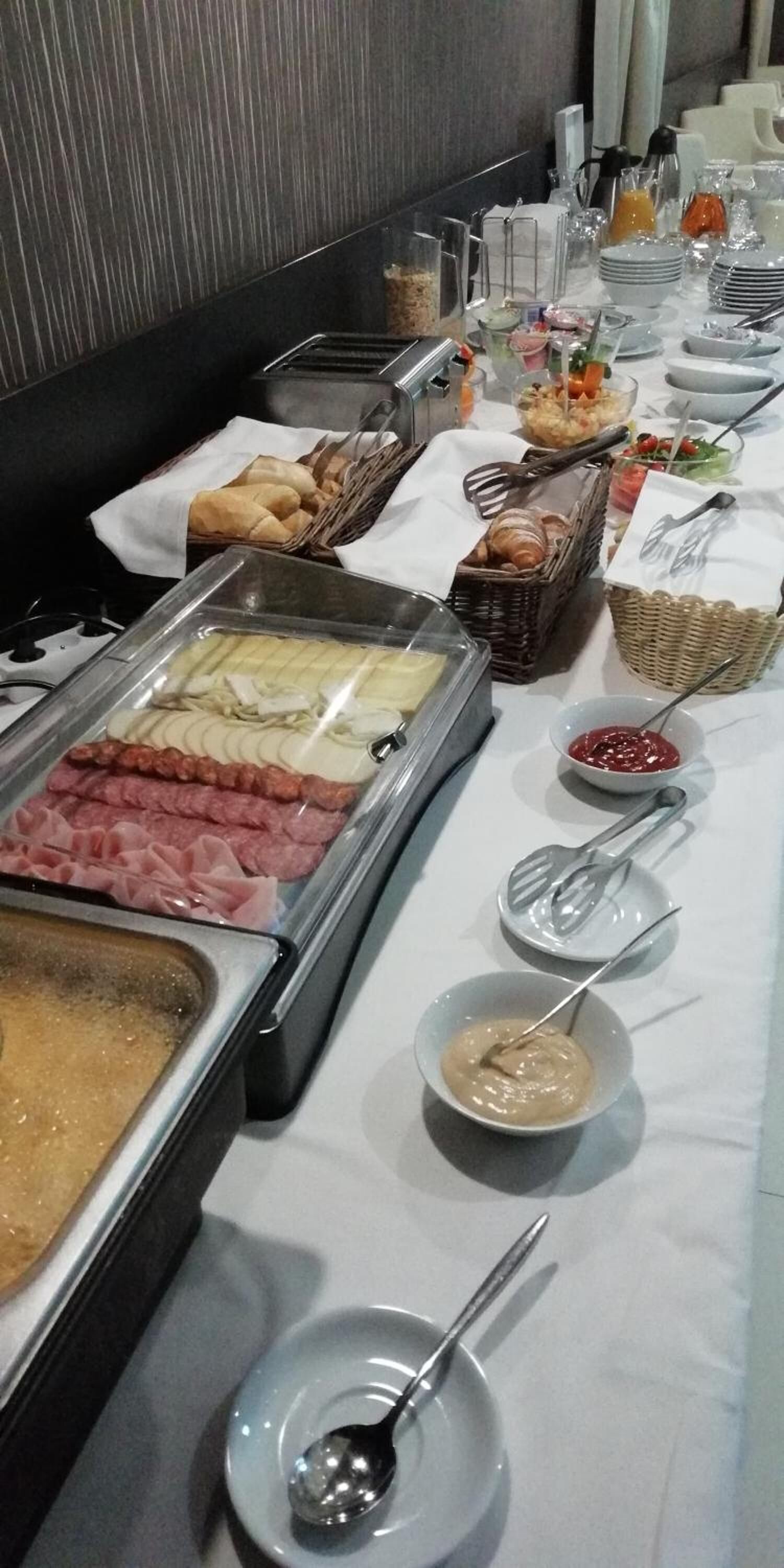 A buffet setup with various food items and utensils.