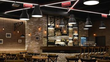 Een restaurant met bakstenen muren, hangende吊りランプ en een bar.