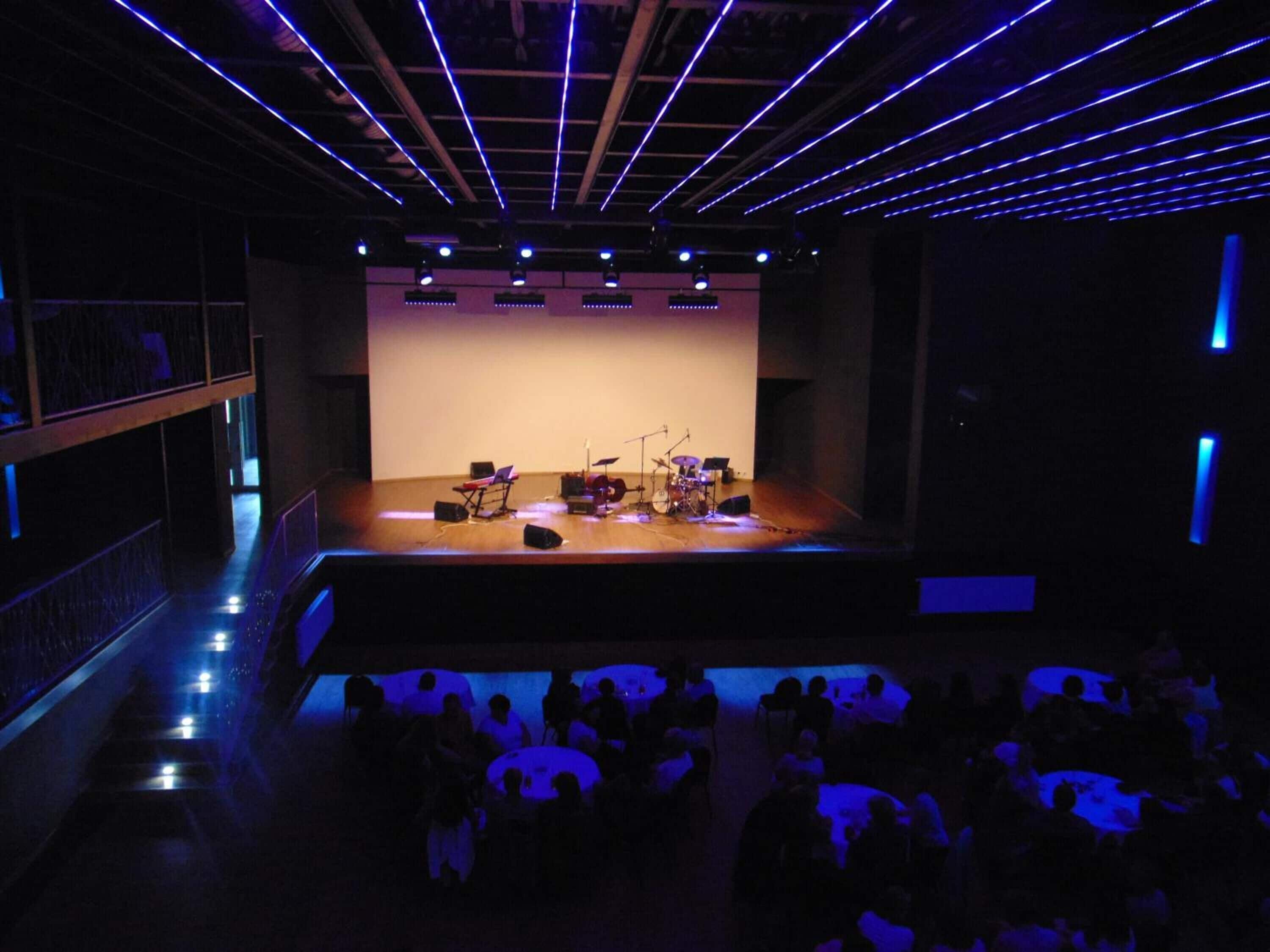 An auditorium with a stage, seating, and a balcony.