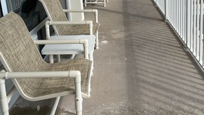 Un espace extérieur abrité, avec des chaises et une vue sur la plage.