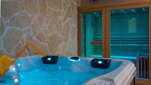 A hot tub with two jets, a stone wall, and a wooden door with a glass panel. - Villa Roza - Studio Apartment with Balcony (Mokosica)