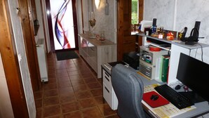 Ein Arbeitszimmer mit Schreibtisch, Computer und verschiedenen Büroutensilien.