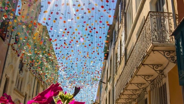 A street with hanging lanterns and vibrant flowers. - Carcassonne, elegant apartment overlooking central square (Carcassonne)