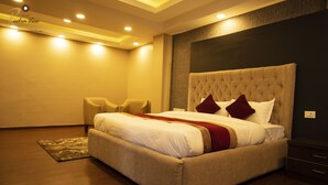 A hotel room with a large bed, a headboard, a bedside table, and a chair. - Hotel Rudra View & Spa (Kathmandu)
