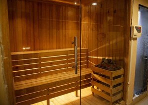 A wooden sauna with a bench and a small wooden shelf with items on it. - Hotel Rudra View & Spa (Kathmandu)