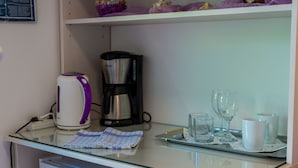 A kitchenette with a coffee maker, a kettle, and a tray with glasses and cups. - Apartments and Room Frane - Double Room (Dubrovnik)