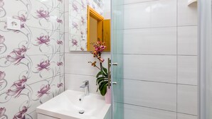 A bathroom with a white sink, a mirror, and a floral wallpaper. - Apartments and Room Frane - Double Room (Dubrovnik)