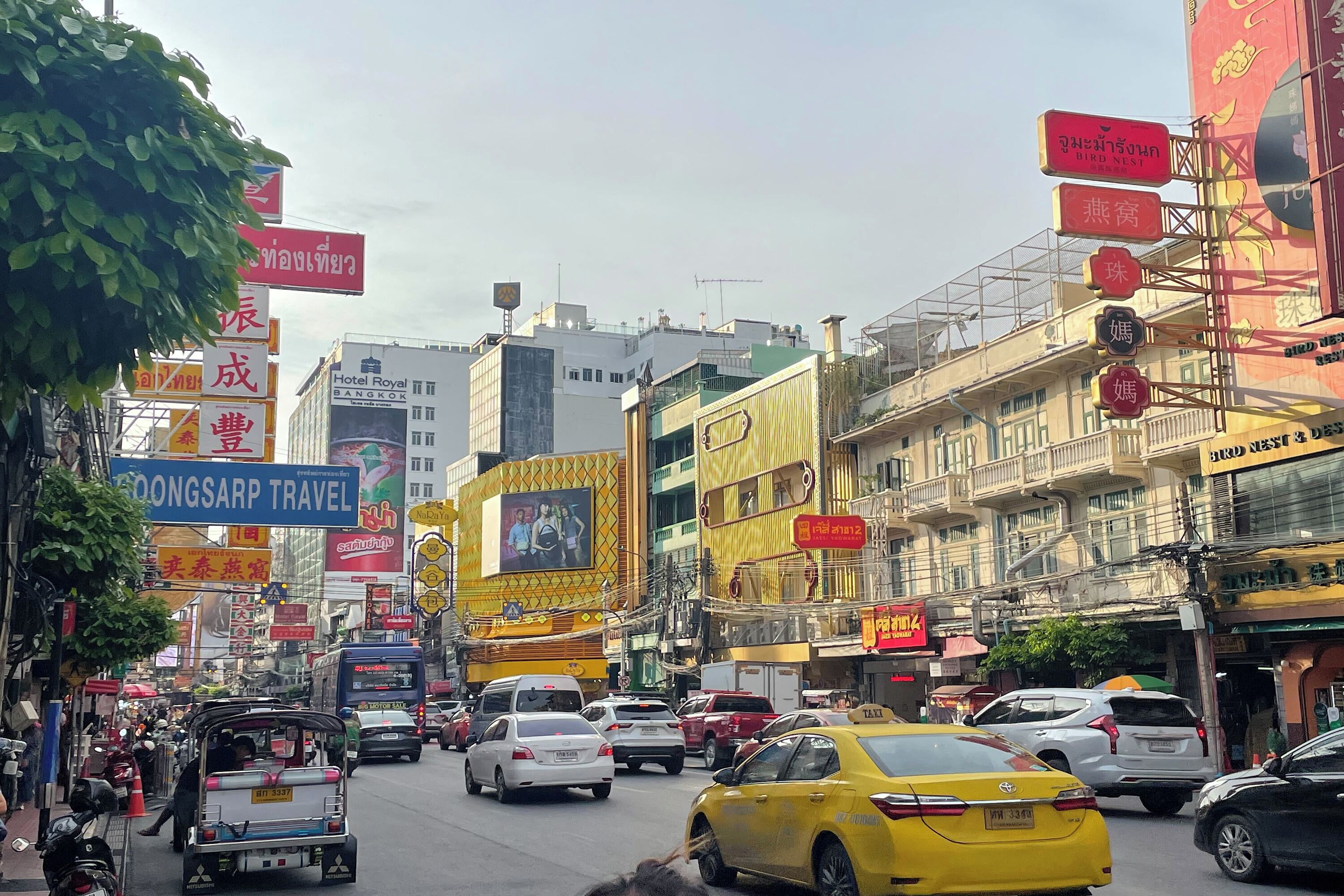 A busy urban street with various vehicles and commercial buildings.