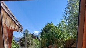 Un patio con vistas a una montaña, una piscina y un porche de madera.