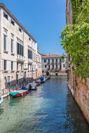 Un canal étroit, bordé de bâtiments historiques dotés de balcons, et un bateau amarré au bord du canal.