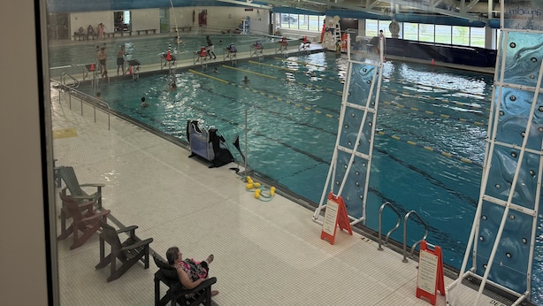 An indoor swimming pool with multiple lanes, lifeguard chairs, and a diving platform. - Stunning 1-Bedroom Furnished Apartment Overlooking Beautiful Halifax Harbour (Dartmouth)