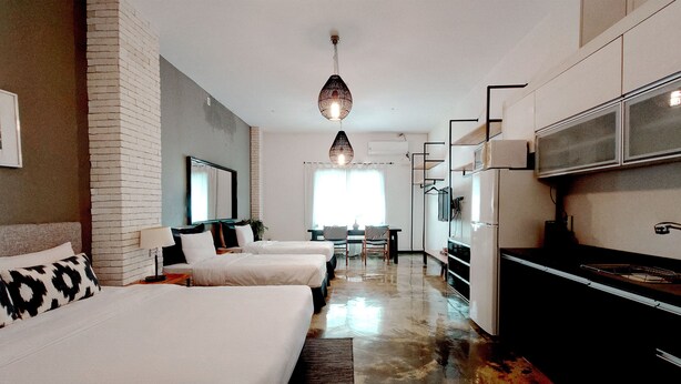 Une chambre d’hôtel avec deux lits, une kitchenette et un coin repas.