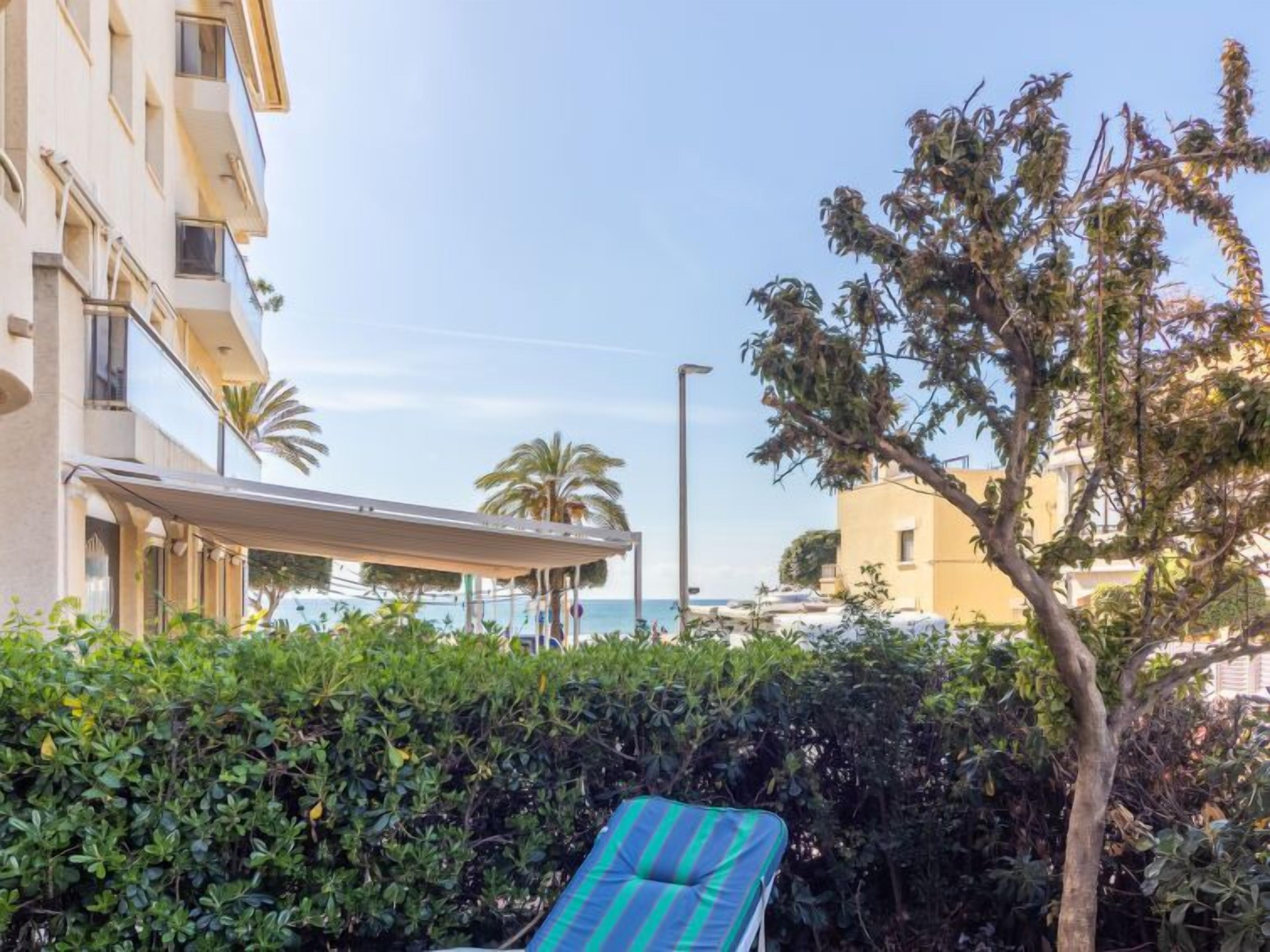 A hotel with a pool, a covered outdoor seating area, and a view of the sea.