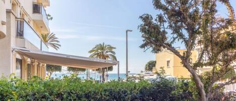 A hotel with a pool, a covered outdoor seating area, and a view of the sea.