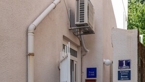 A narrow hallway with a white door, a small air conditioning unit mounted on the wall, and a sign indicating room number 1. - Rooms Edna - Twin Room (Dubrovnik)