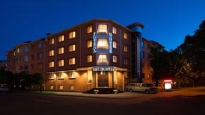 A multi-story hotel with a prominent 'Helicopter' sign, a corner entrance, and a visible elevator shaft. - Hotel Helicopter (Kremenchuk)