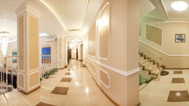 A grand hallway with a staircase, ornate columns, and a chandelier. - Hotel Helicopter (Kremenchuk)
