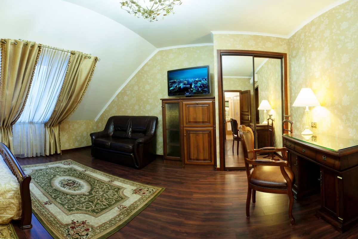 Une chambre d’hôtel équipée d’un lit, d’un bureau, d’une chaise, d’une télévision et d’une salle de bain avec douche.