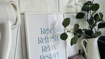 A framed sign with the words 'Reset Refresh Relax Restart' on a tiled wall.
