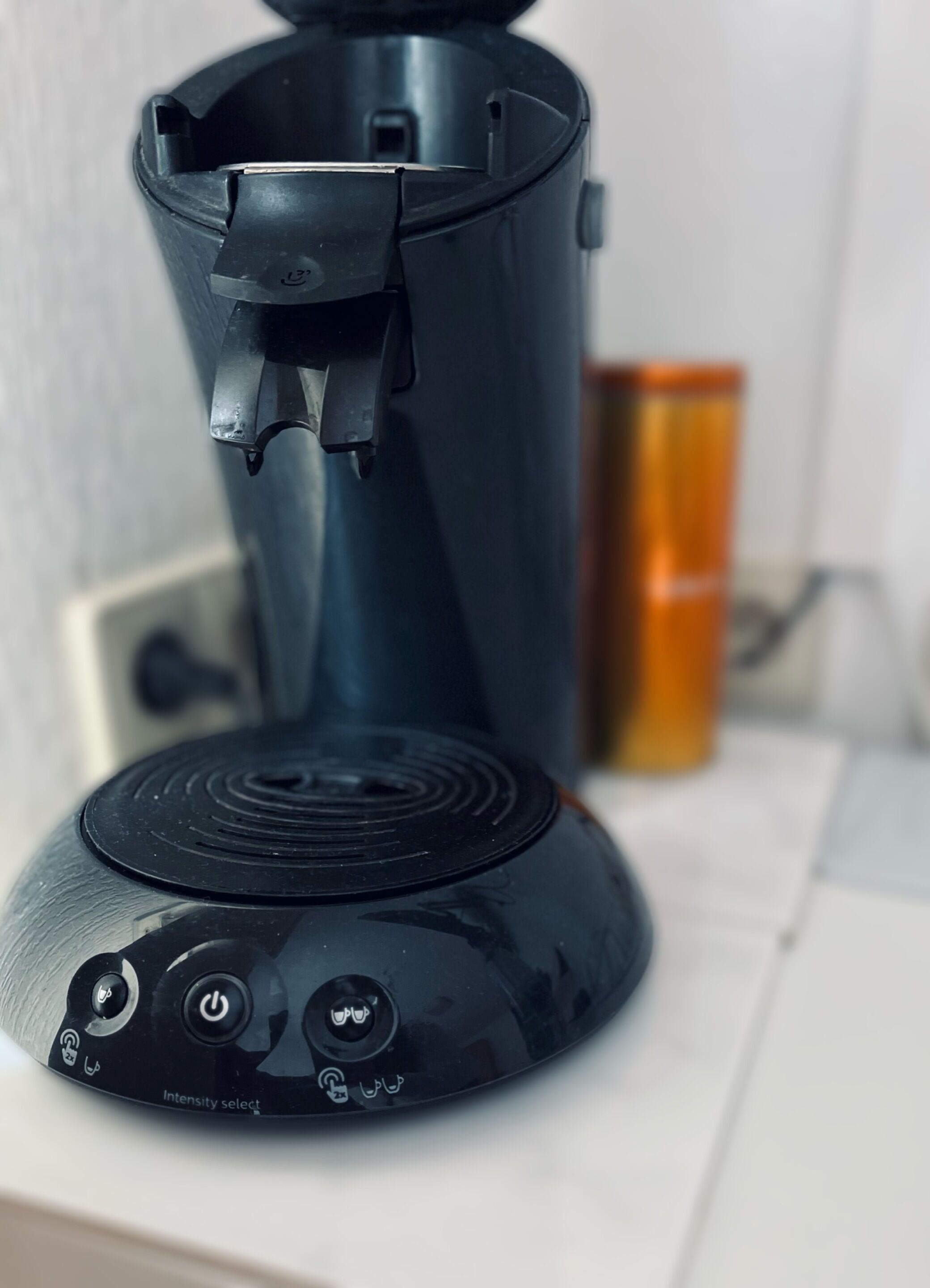 A coffee maker with a water reservoir and a power button.