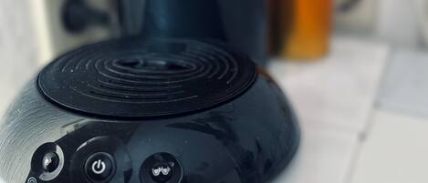 A coffee maker with a water reservoir and a power button.