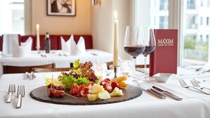 Una mesa de comedor con varios aperitivos, copas de vino y una carta.