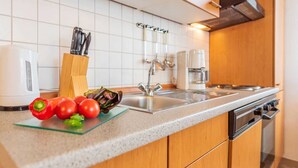 Una cocina moderna con encimera de granito, pileta de acero inoxidable y muebles de madera.