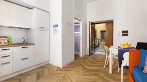 A compact kitchen with white cabinets and a herringbone wooden floor. - AMORE RENTALS - Casa 80 with Air Conditioning and Internet WI-FI (Sorrento)