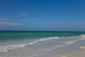 Enjoy a serene beach experience with gentle waves and ample space for relaxation and activities.