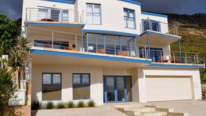 A two-story house with a garage, a balcony on the upper floor, and a driveway leading to the garage. - Magellans Hotel (Cape Town)