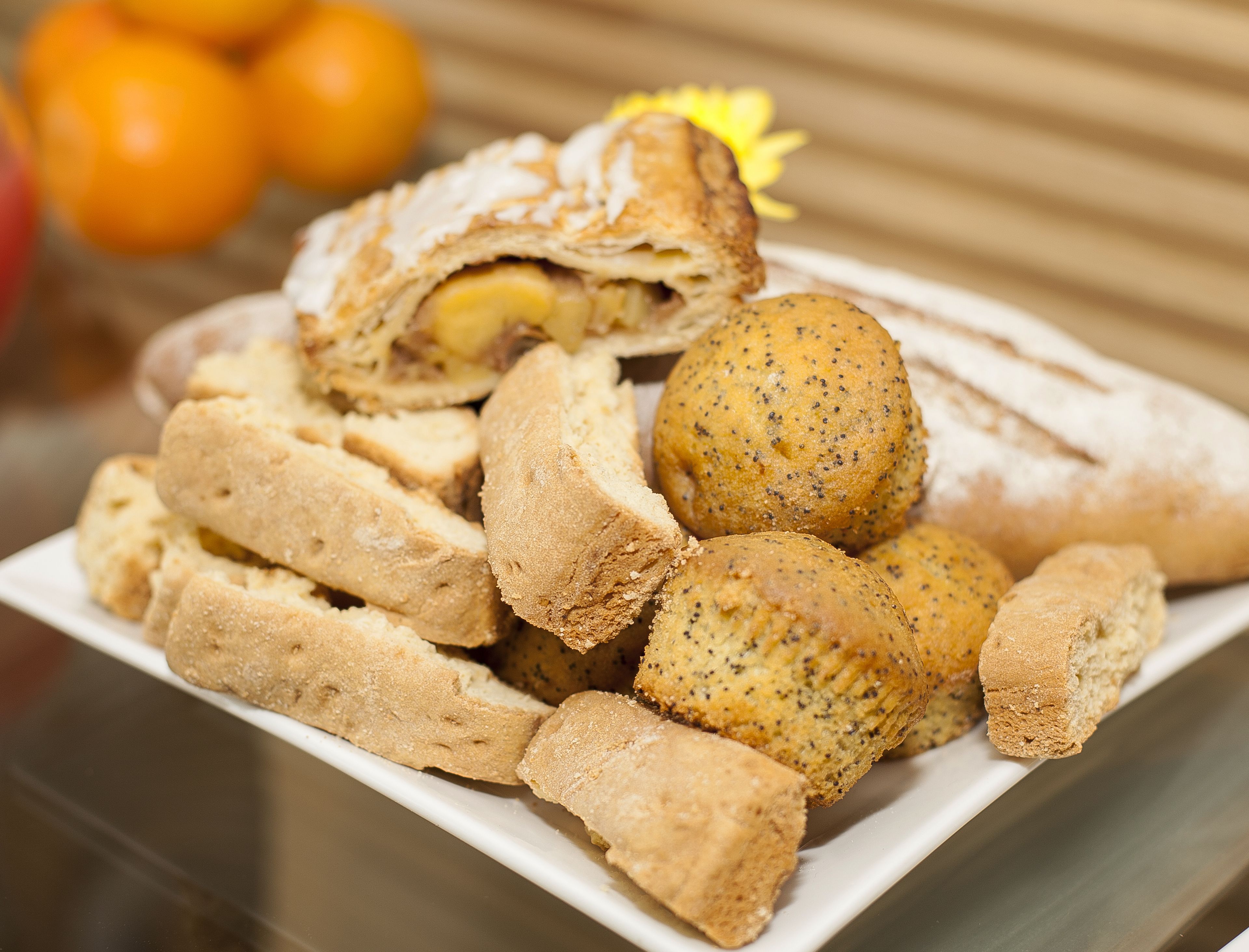 A plate of assorted baked goods, including bread rolls and a stuffed pastry.