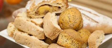 A plate of assorted baked goods, including bread rolls and a stuffed pastry.