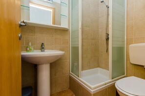 Un baño con ducha, lavamanos e inodoro.