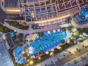 An aerial view of a hotel with a swimming pool, landscaped gardens, and a modern building structure. - Crowne Plaza Beihai Silver Beach by IHG (Beihai)