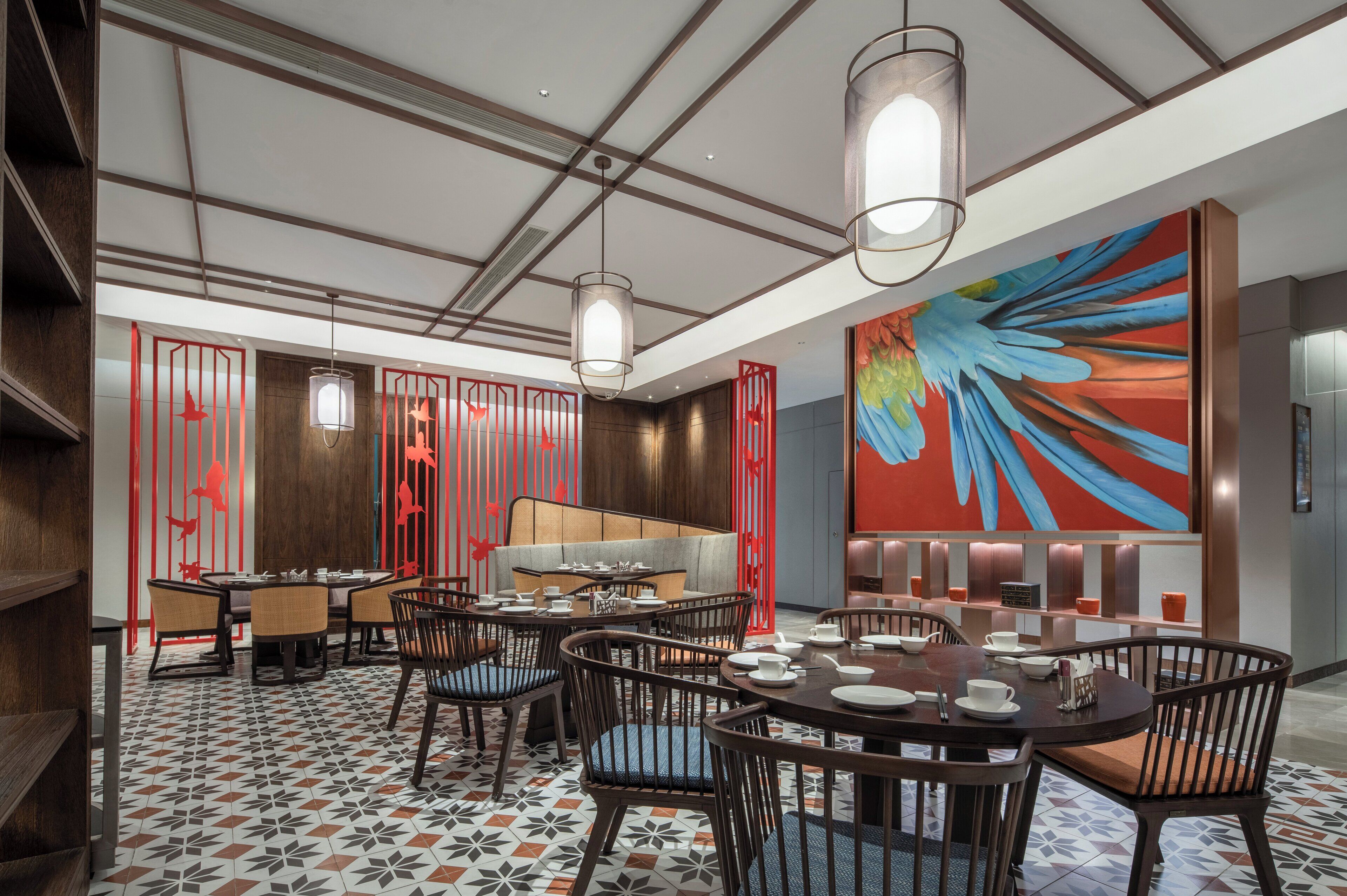 A modern dining area with round tables, chairs, and a large abstract painting on the wall.